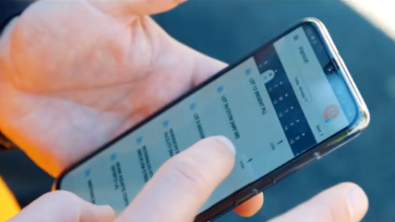 Hände halten ein Smartphone und bedienen eine App