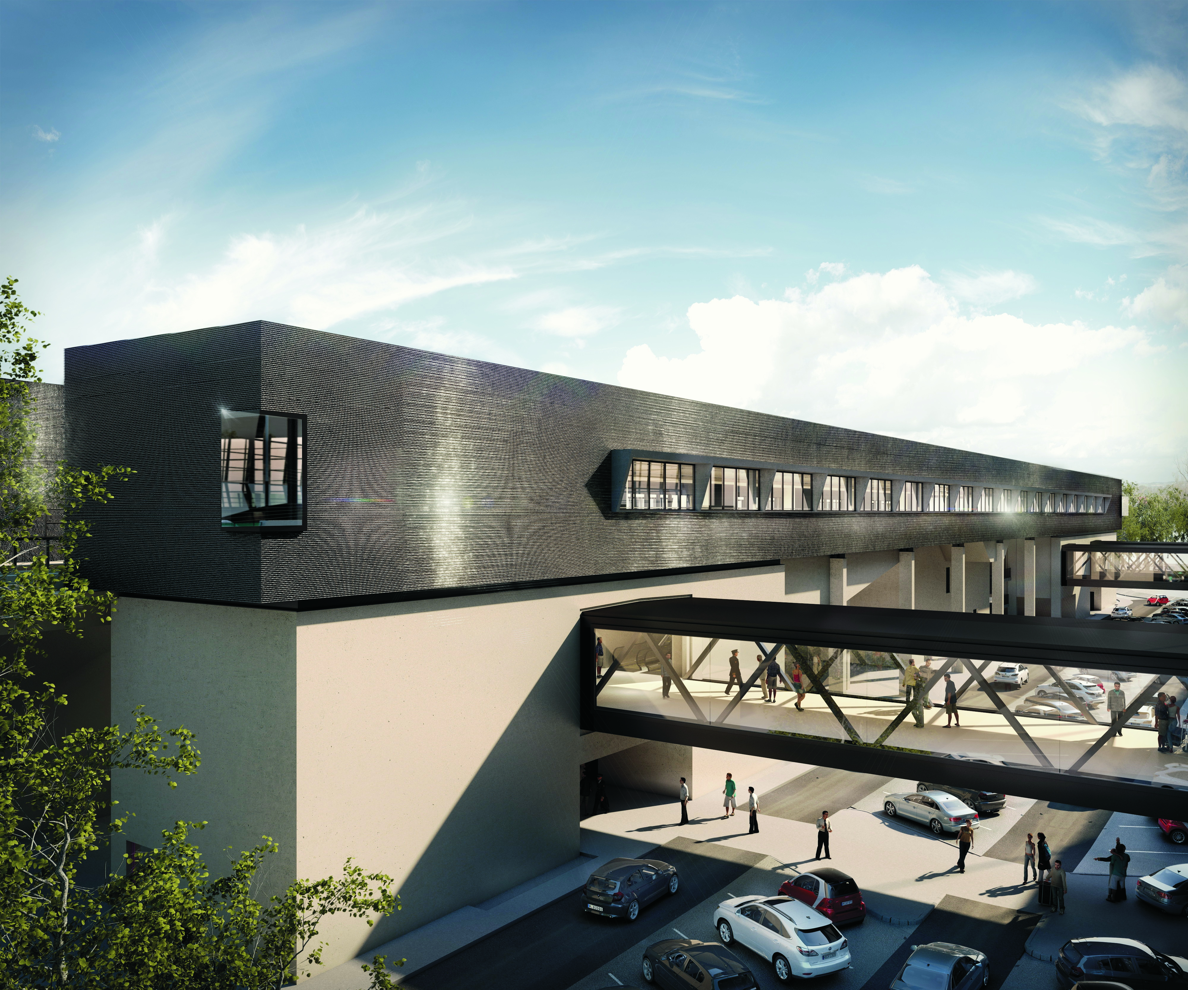 Building with glass bridge, cars parked underneath