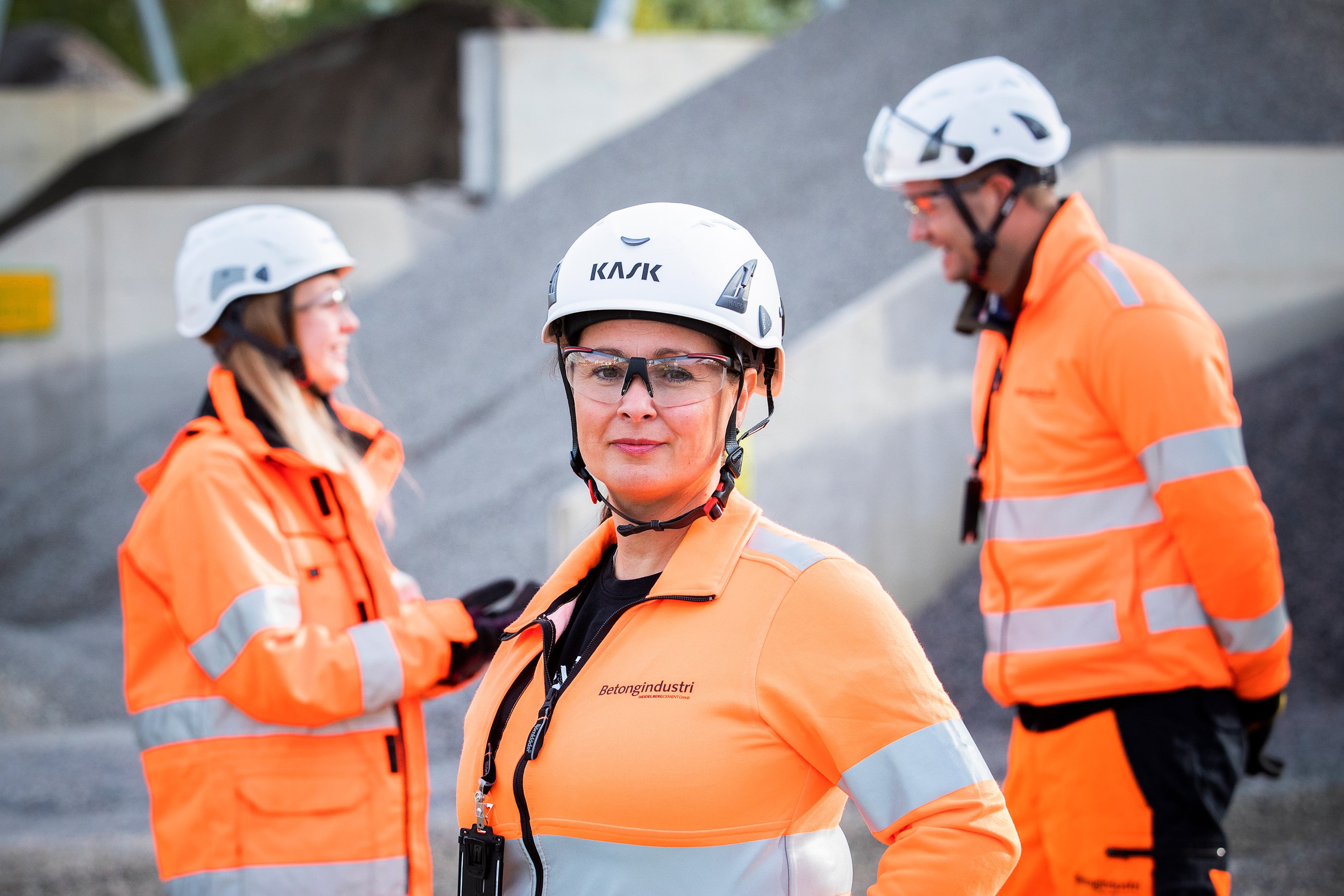 Employees wearing white helmets and orange vests
