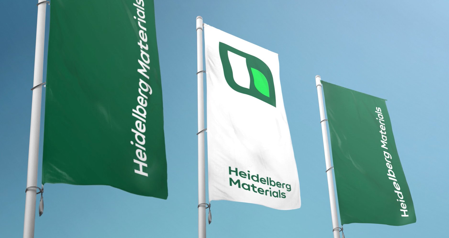 Drei Fahnen im Wind mit dem Heidelberg Materials-Logo darauf