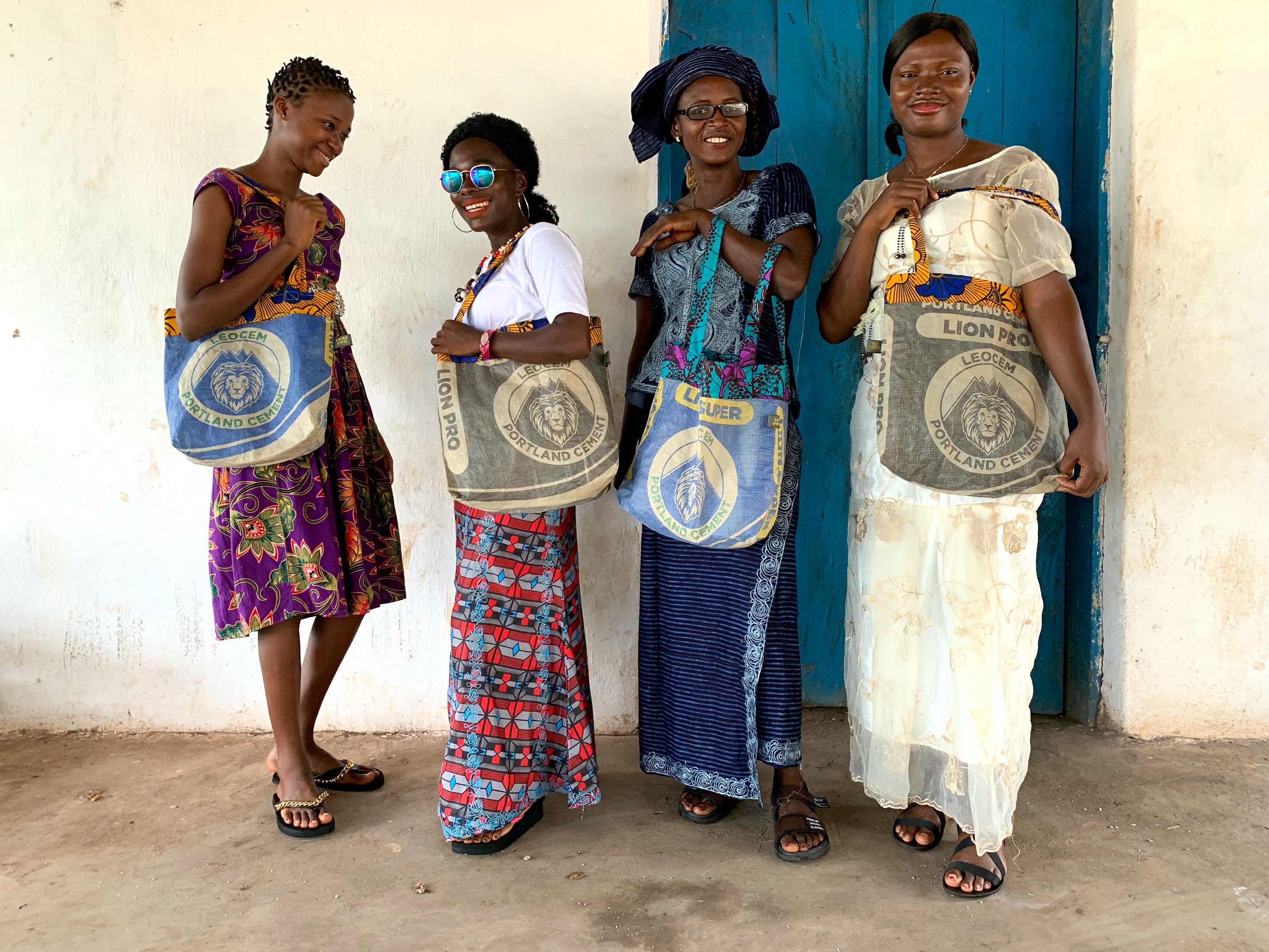 Four women from Sierra Leone with colourful bags with lions on it