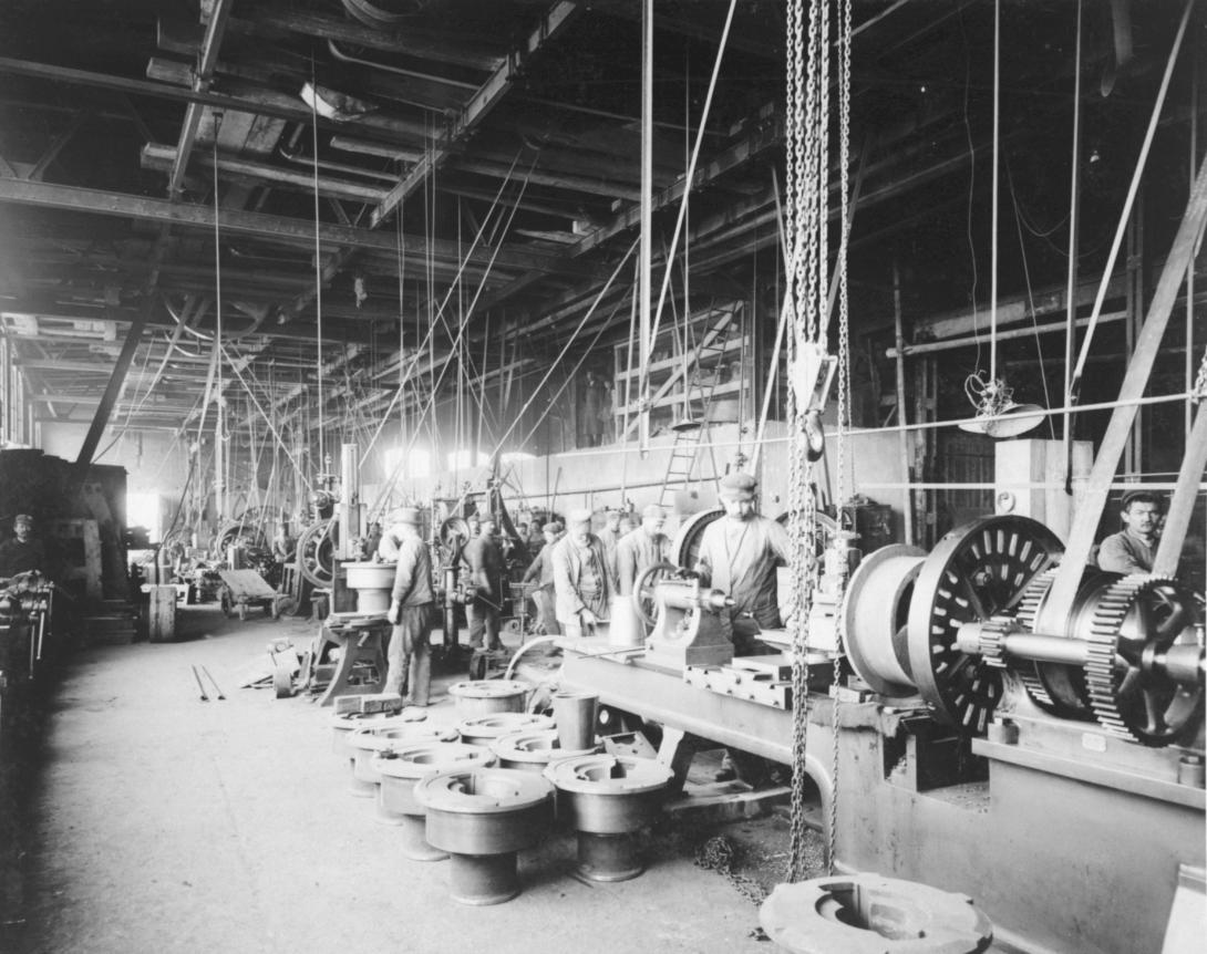 Arbeiter in einer Halle mit Maschinen