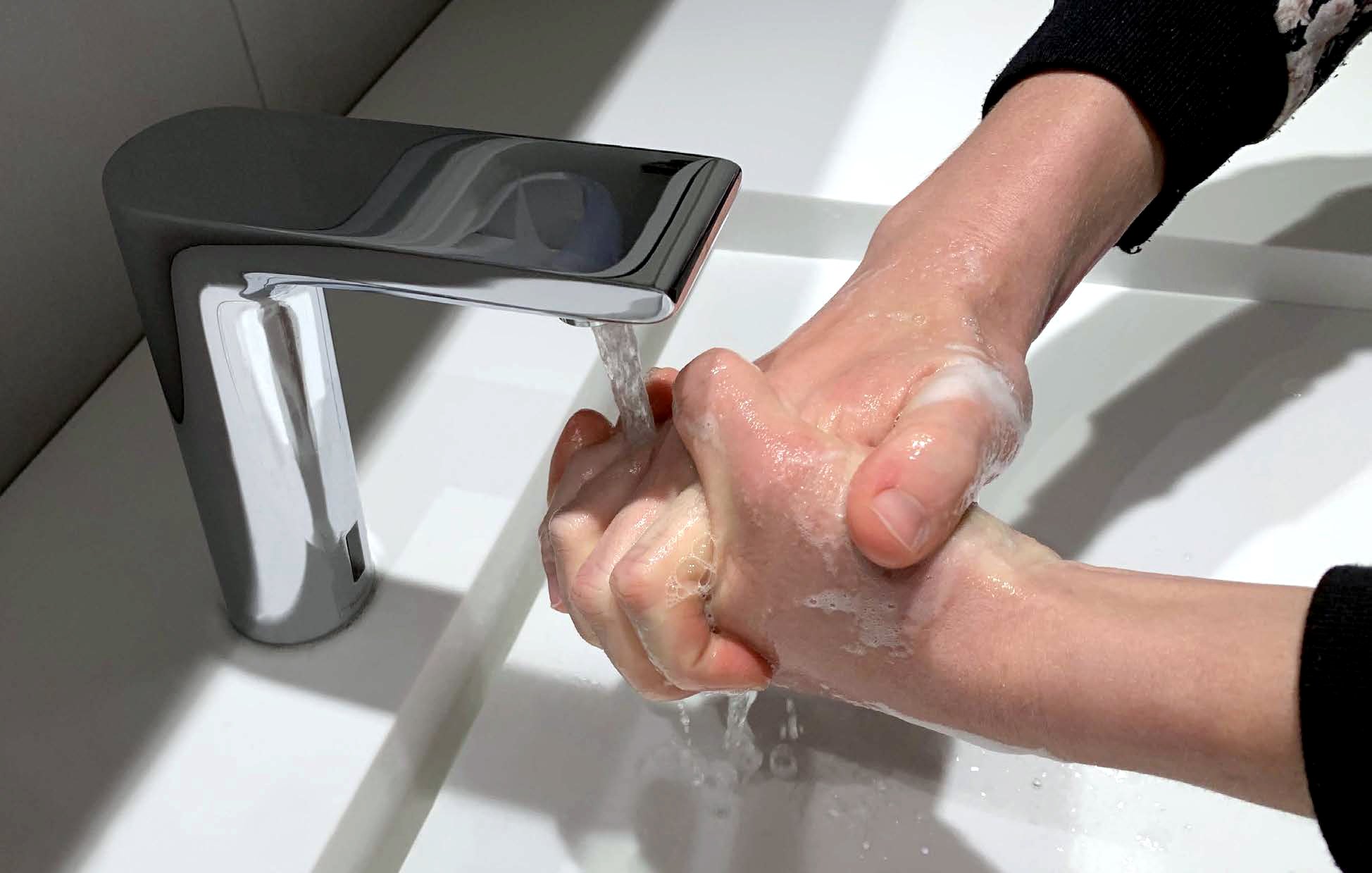 Hands under a water tap
