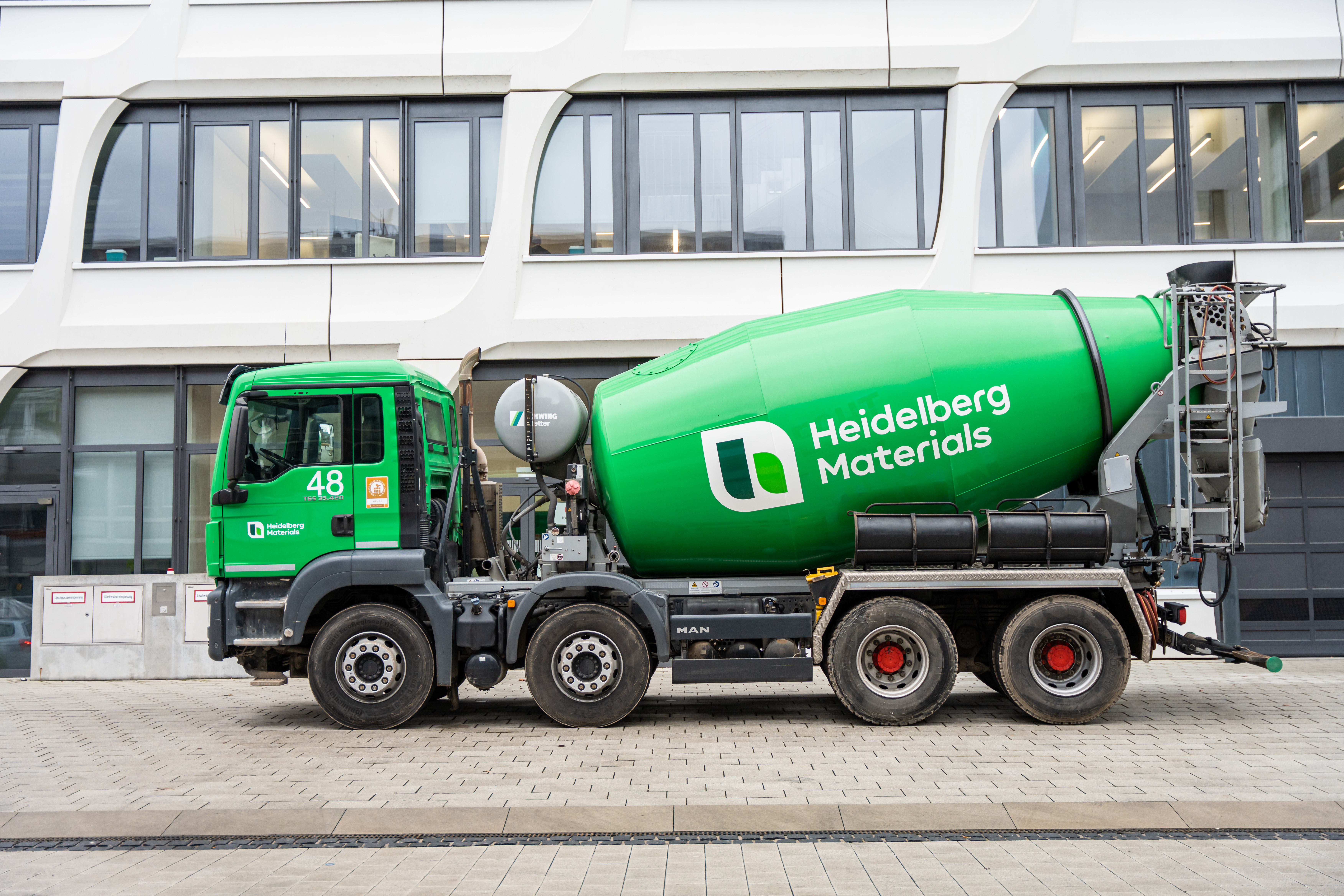 Green ready-mix truck stands in front of the Heidelberg Materials Headquarters