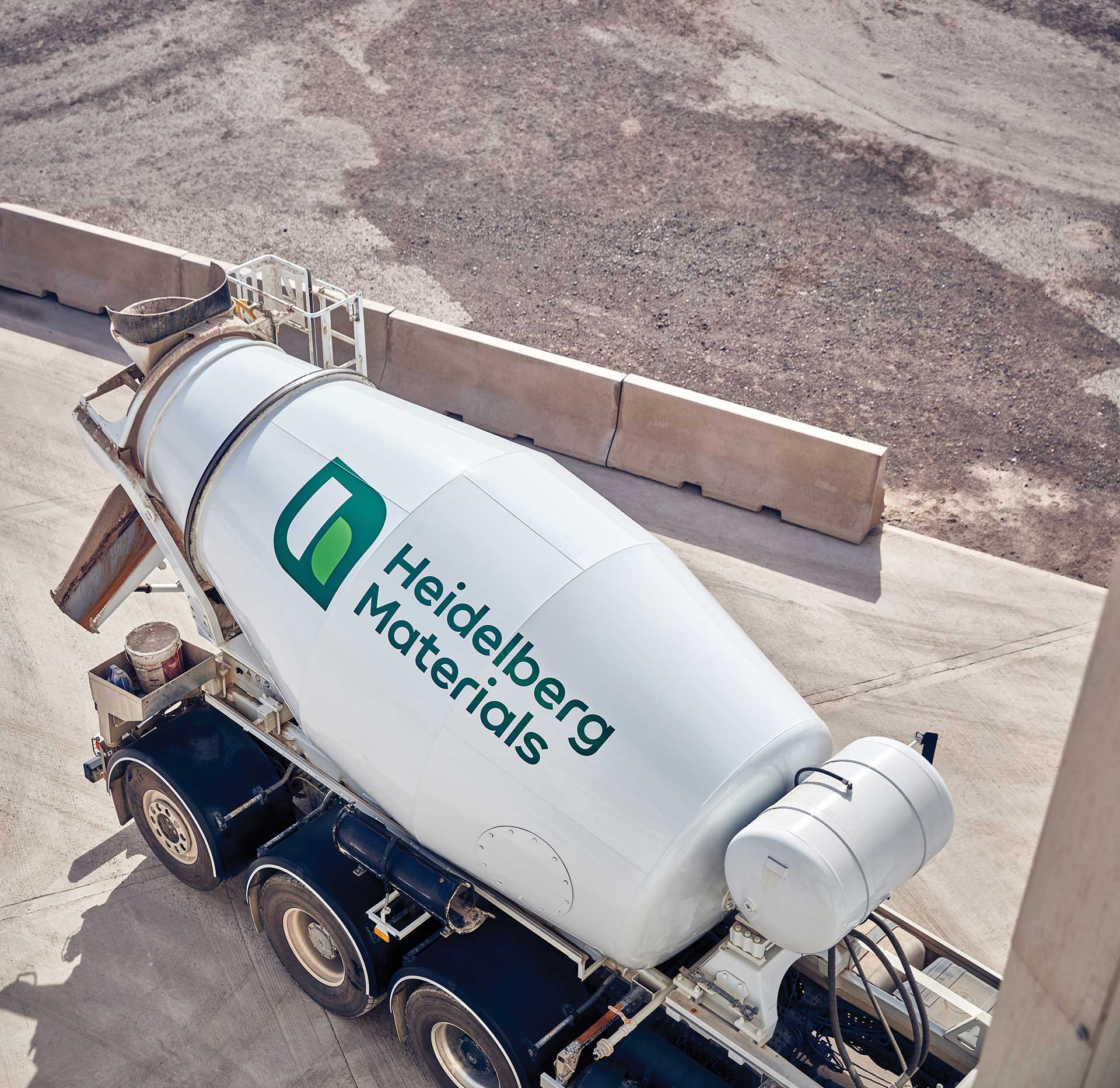 A Heidelberg Materials cement mixer truck is parked at an industrial site.