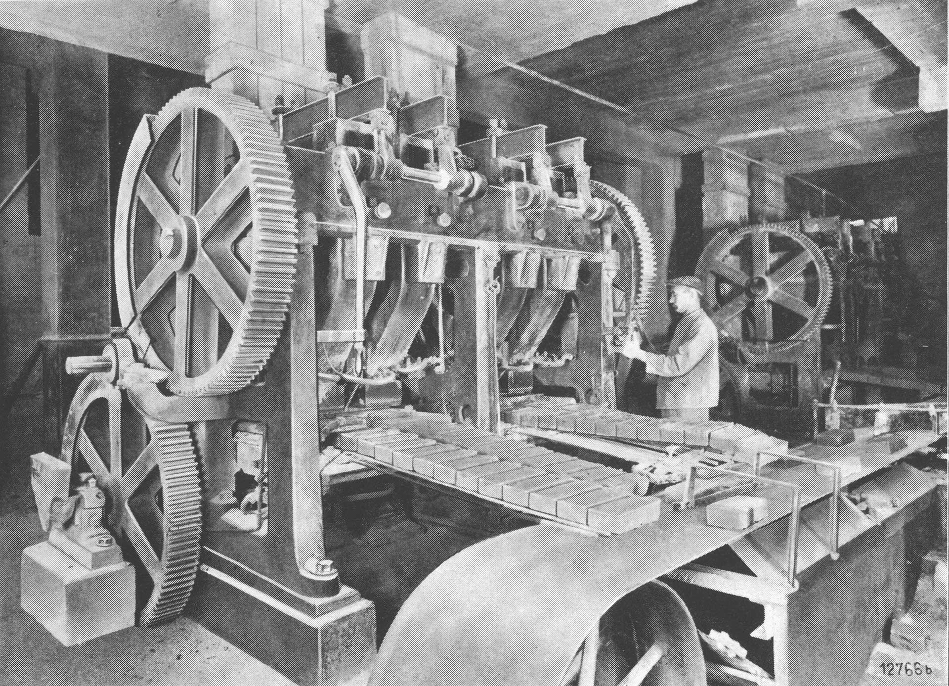 Ein Arbeiter bedient eine große Industriemaschine in einer Produktionsstätte.