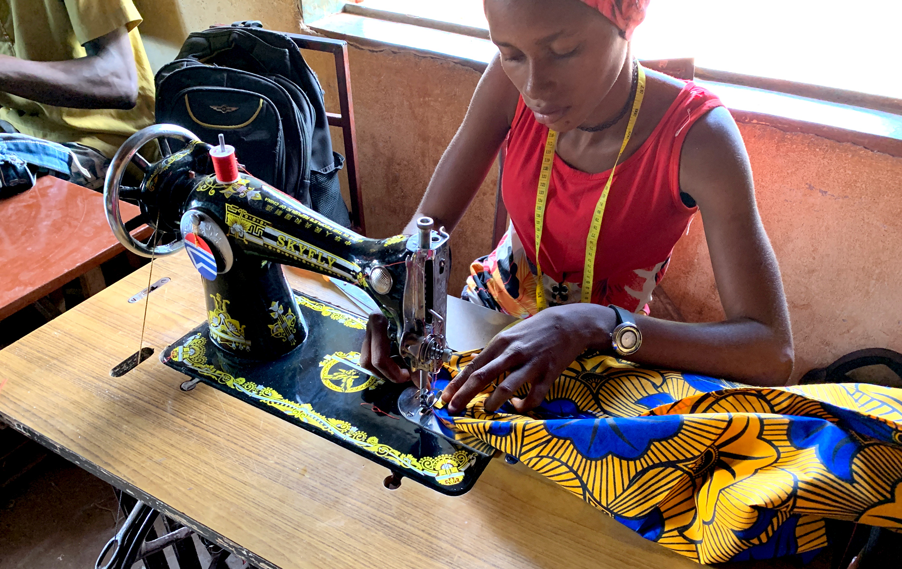 A seamstress lining bags with brightly coloured fabrics