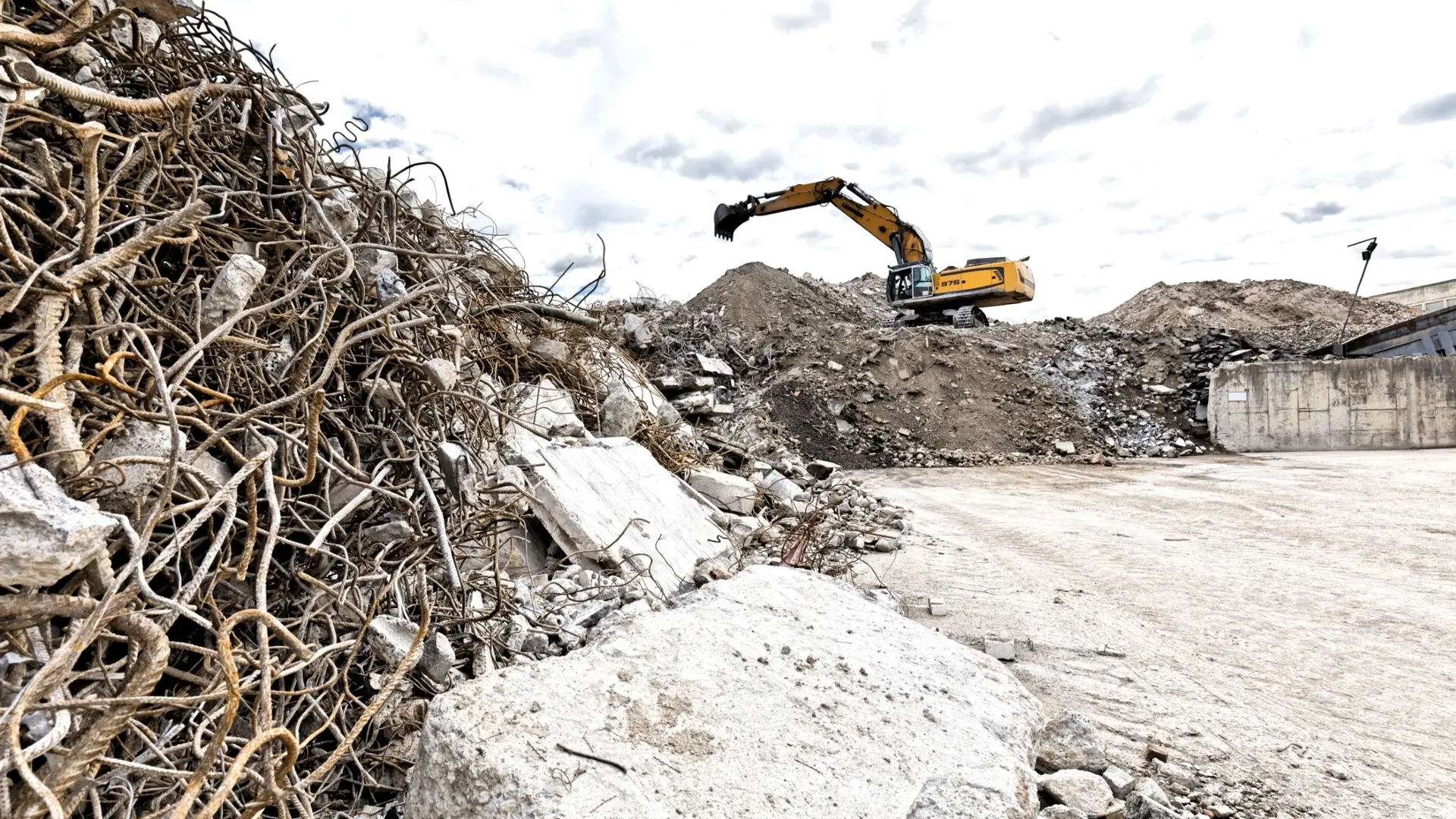 An excavator on a pile of rubble