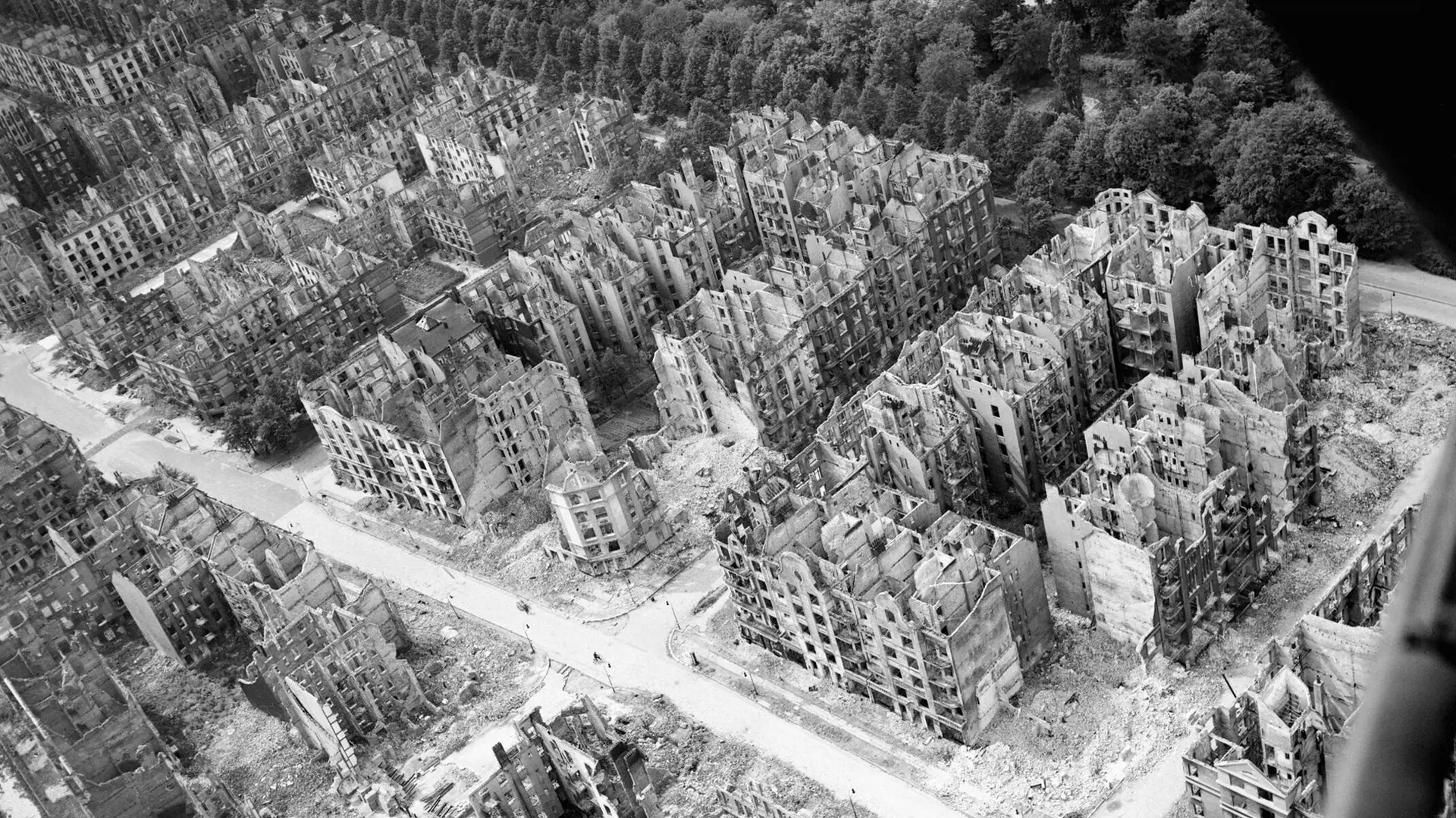 Oblique aerial view of ruined residential and commercial buildings south of the Stadtpark (seen at upper right) in the Eilbek district of Hamburg, Germany.