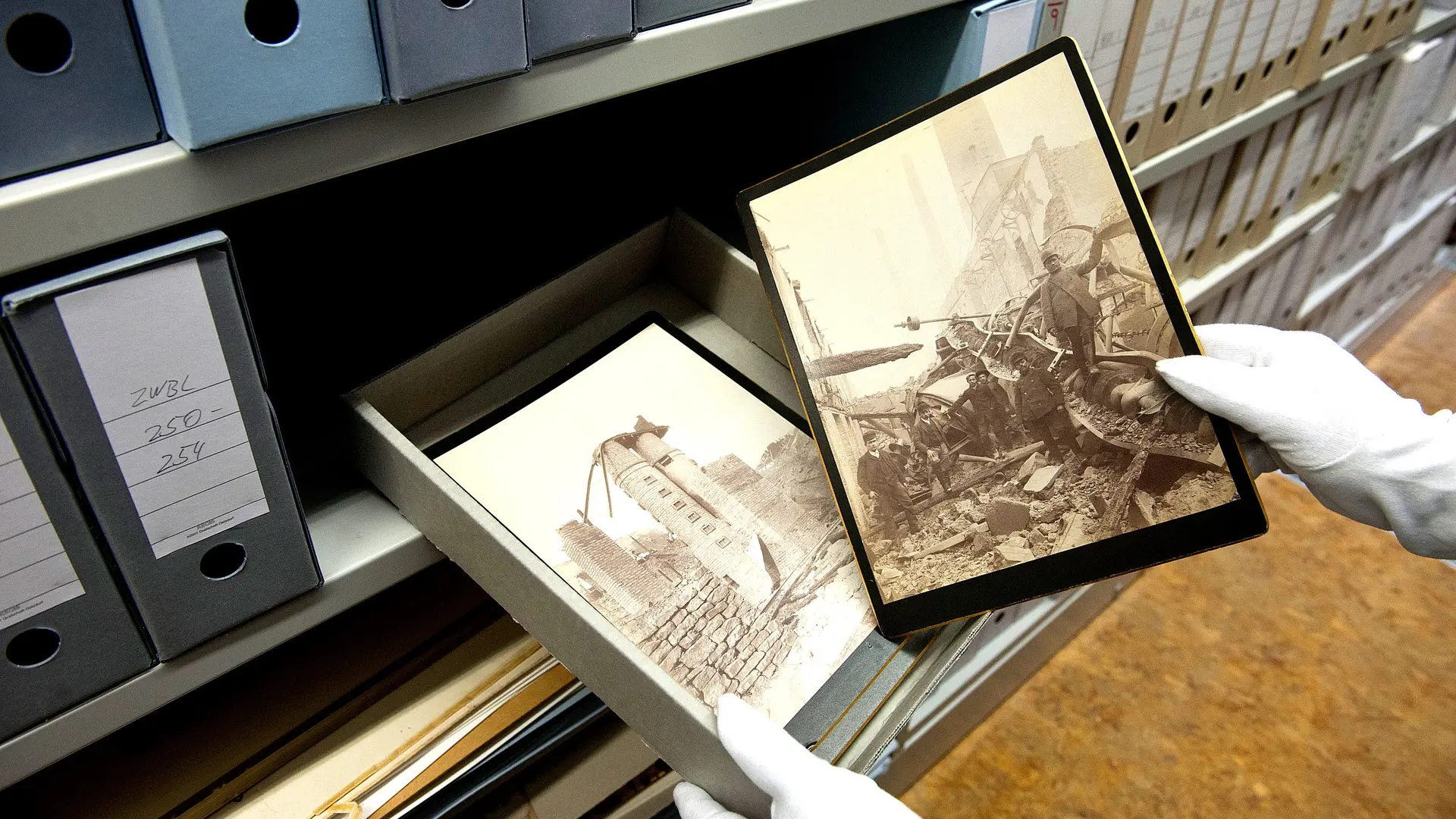 Gloved hands take historical footage out of a slipcase