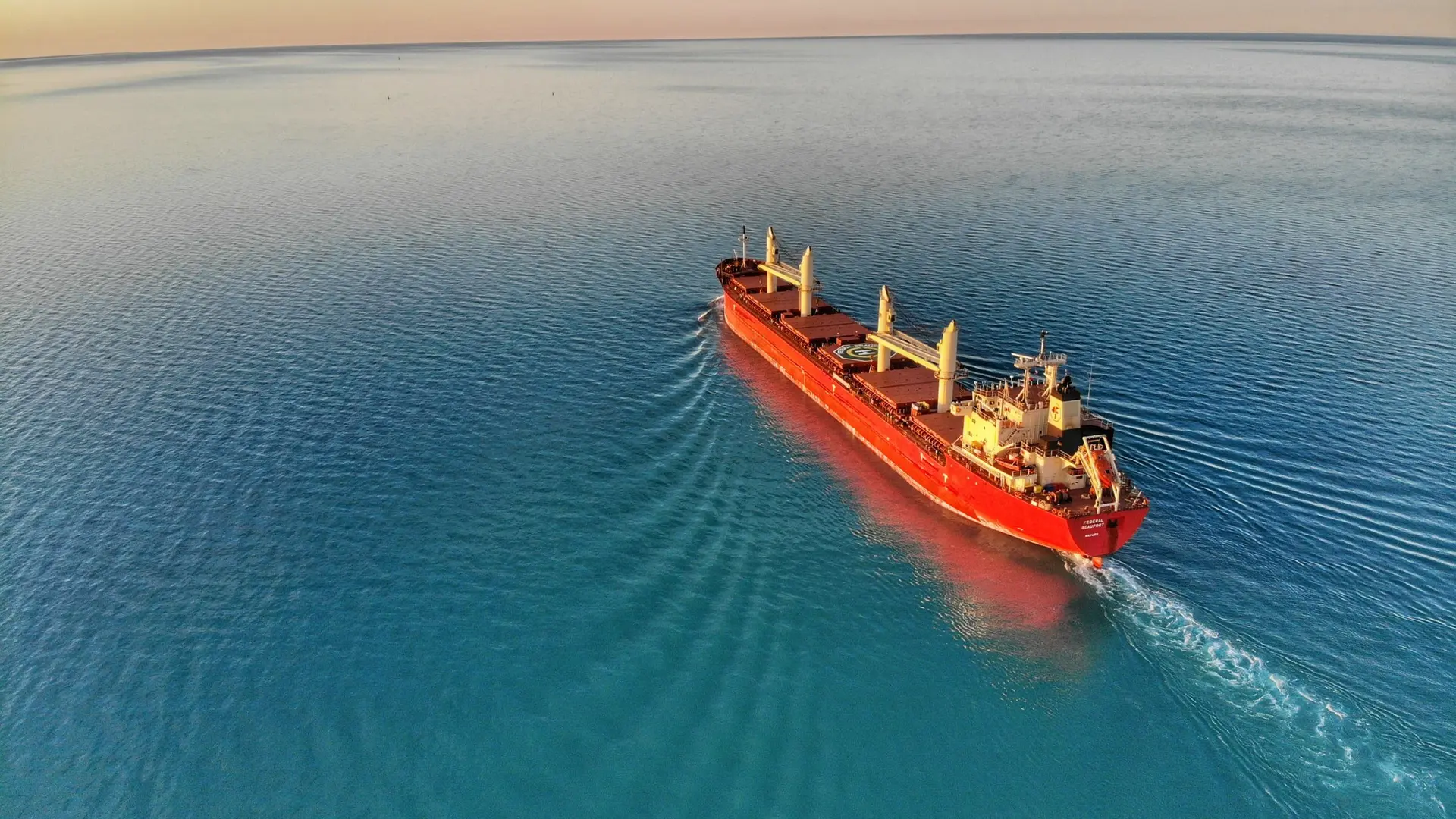 A red ship is sailing on the sea