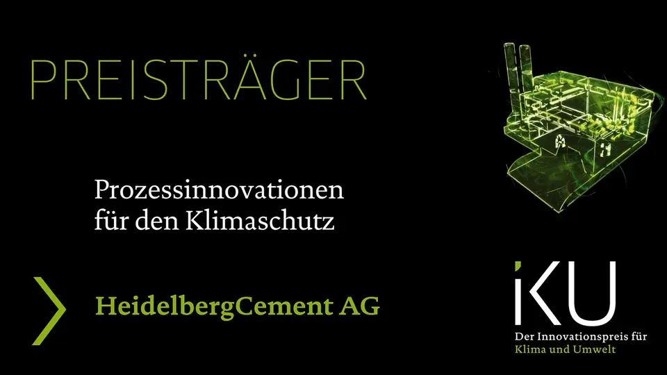 Eine Preisverleihung für die HeidelbergCement AG zur Anerkennung ihrer Prozessinnovationen für den Klimaschutz. Das Bild zeigt eine grün beleuchtete Umrisszeichnung einer Fabrik auf schwarzem Hintergrund.