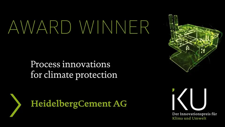 An award ceremony for HeidelbergCement AG to recognise its process innovations for climate protection. The picture shows a green illuminated outline drawing of a factory on a black background.