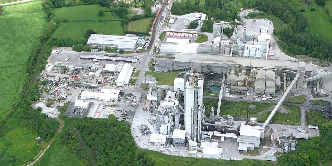 Aerial view of an industrial complex amid green fields, highlighting the contrast between industry and nature