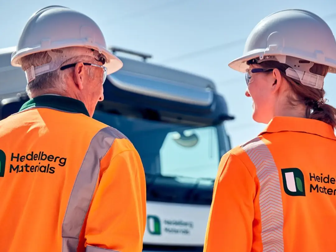 Drei Arbeiter*innen in Sicherheitsjacken mit einem Logo von Heidelberg Materials auf dem Rücken