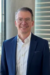  Robert Adolph vor einer Betonsäule und einem Fenster mit Blick auf den Neckar