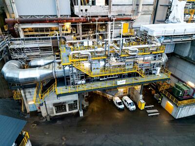Aerial view of a large industrial facility with a complex network of pipes, machinery, and platforms.