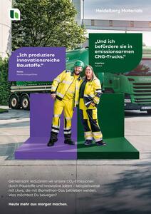 A female CNG truck driver and a blue-collar employee, both in protective clothing on a stage in a cement plant, with a CNG truck in the background
