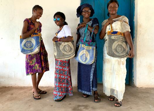 Four women from Sierra Leone with colourful bags with lions on it