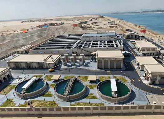 Aerial view of a large water treatment facility near a coastline. 